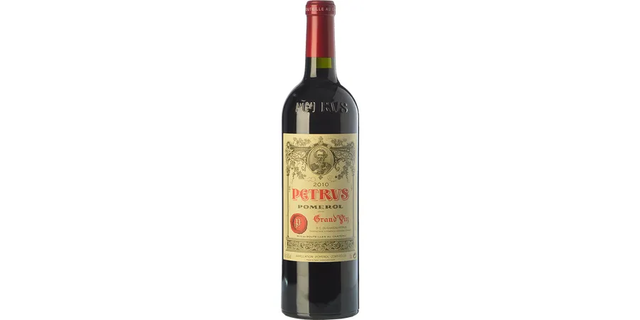Petrus Pomerol Merlot vintage bottle resting on display under secure vault lighting showing its signature elegant cream label with simple red lettering and a matching red capsule.